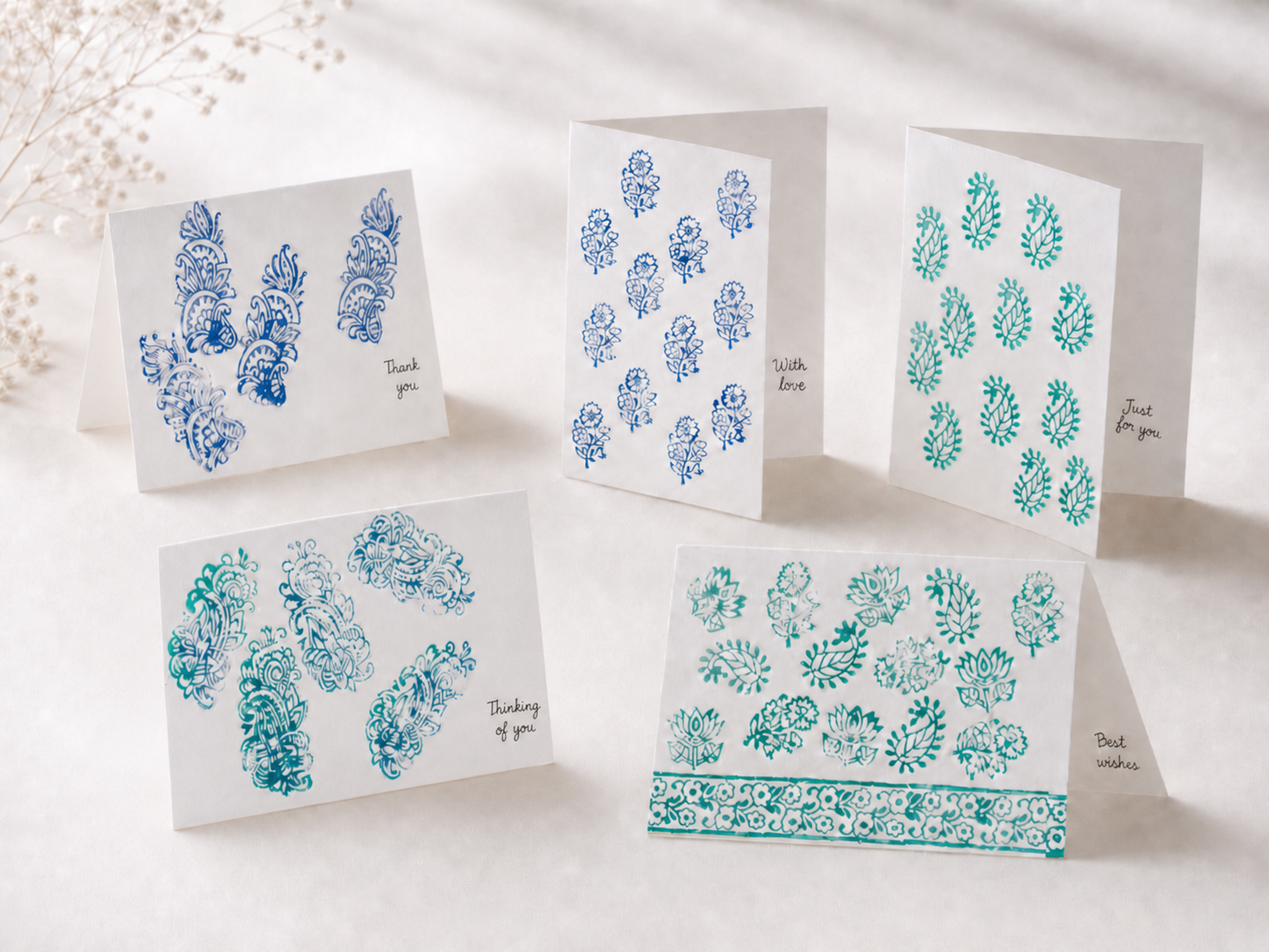 Set of greeting cards with blue and green floral patterns on a white background