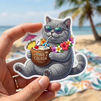 Sticker of a cat drinking a Pina Colada held by a hand on a beach background